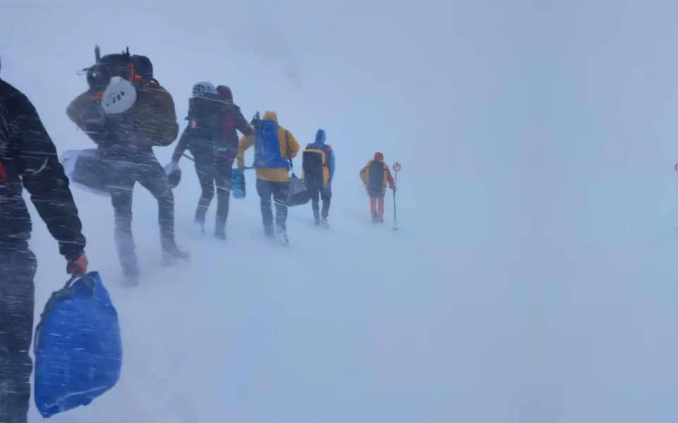 Téli magashegyi tanfolyam - 3 nap az Alpokban MountainGo módra 13 Emerek sorban haladnak a hófúvásban - Téli magashegyi felkészítő